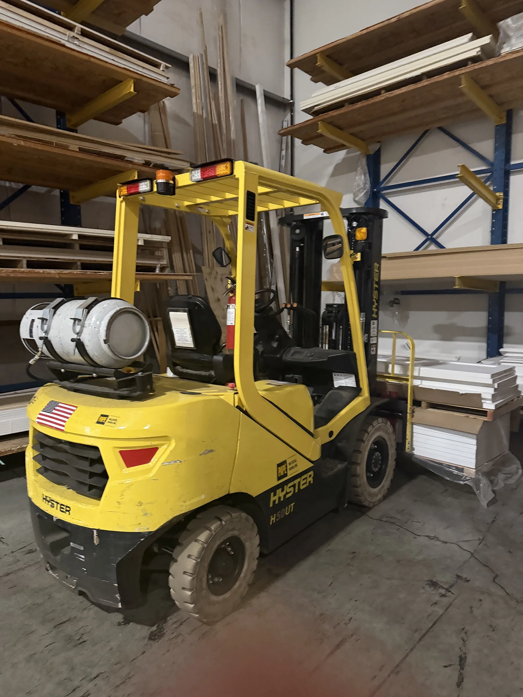 Yellow forklift beside organized door and trim inventory inside the Moore's Doors warehouse